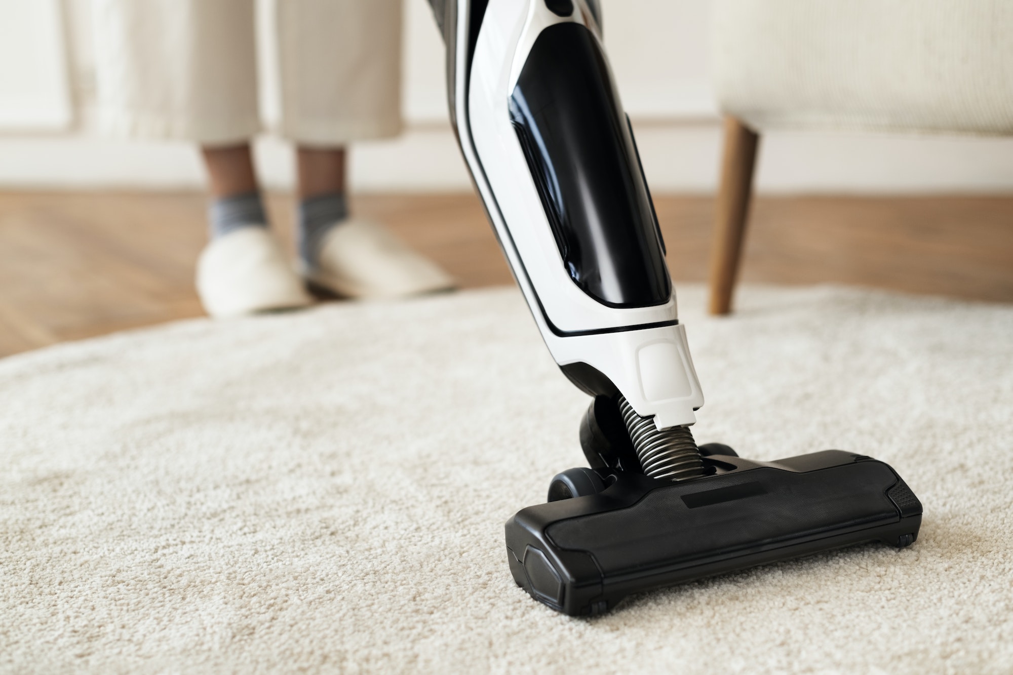 Vacuum cleaning a rug on the floor